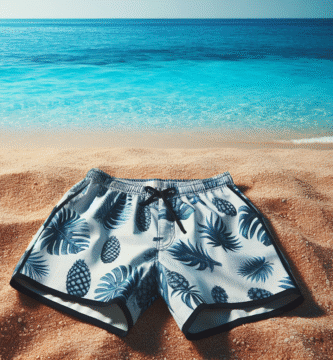 An image of a modern swimming short, laying on a beach with clear blue water in the background, showcasing a blend of style and function.